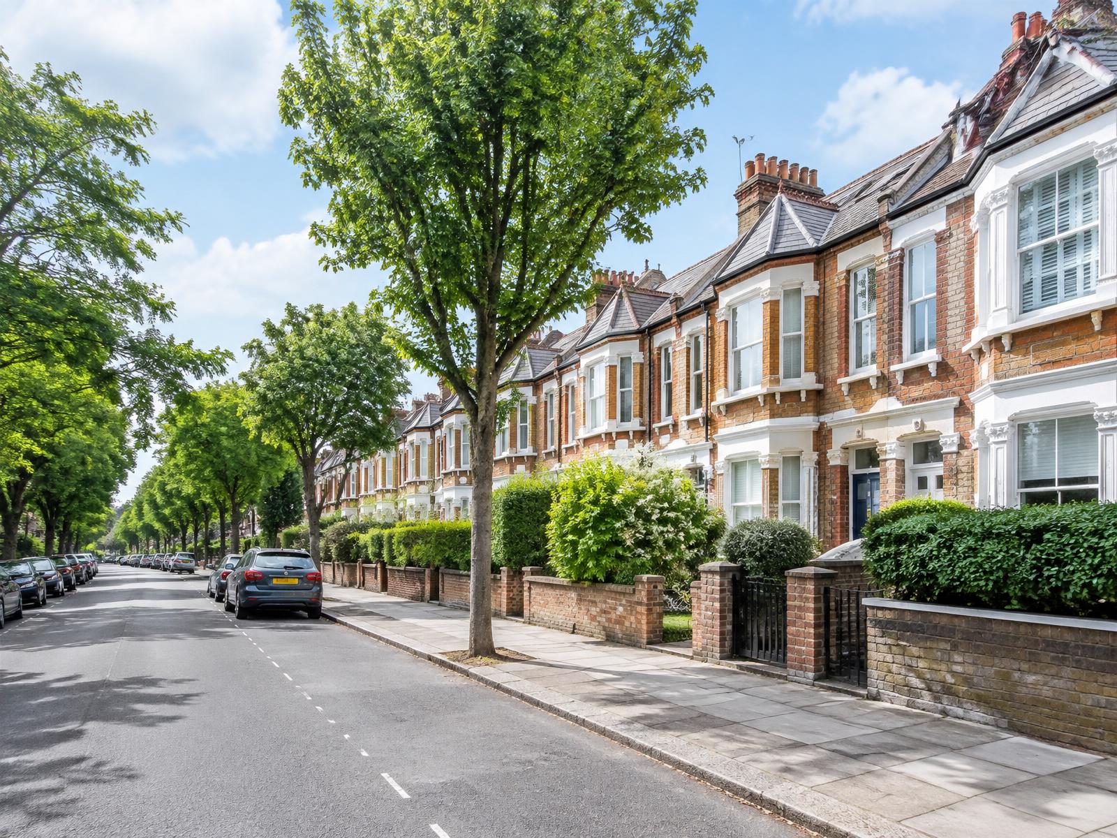 Tree-lined UK residential street with Victorian terraced homes
